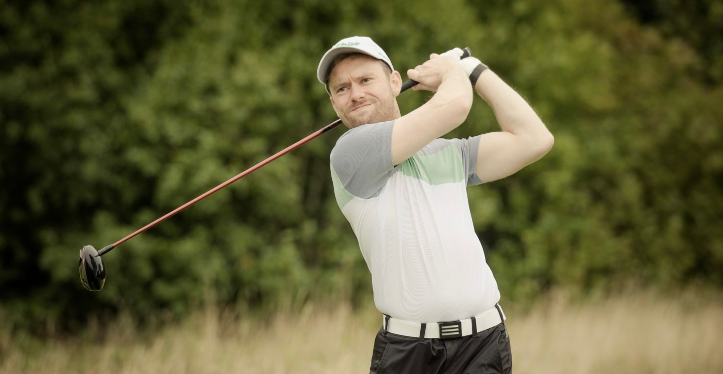 Gary Shaw following through after a golf shot.