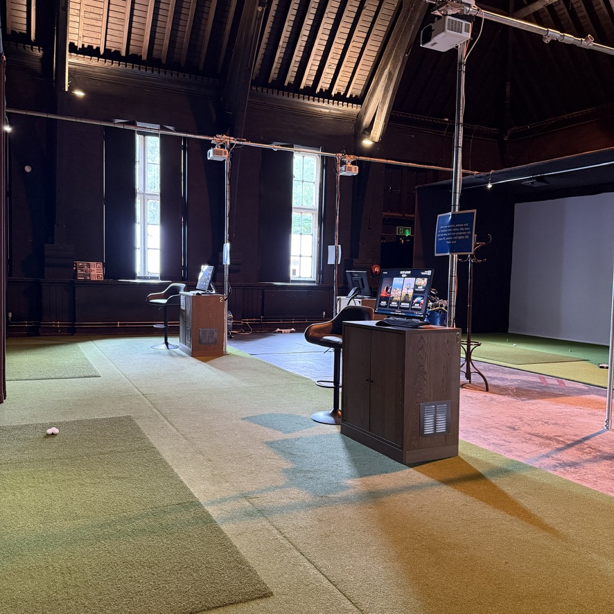 Golf simulator bays beneath the timber roof at SGC Wandsworth Common.
